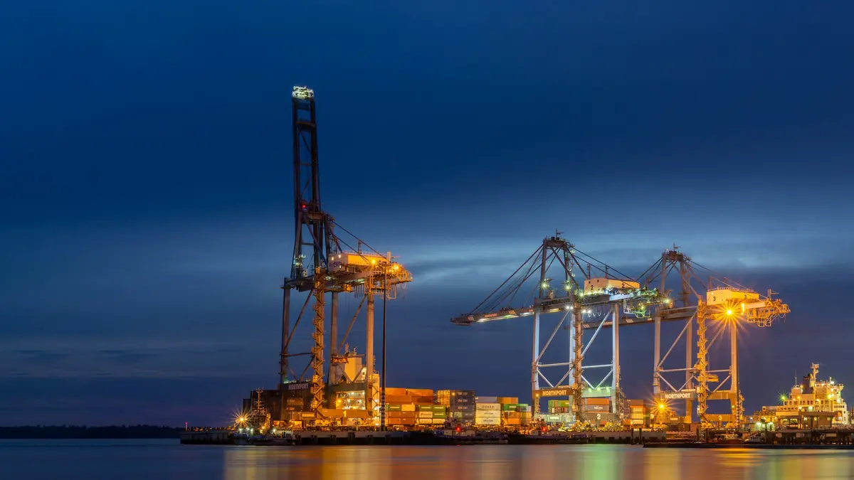 Grúas de una terminal portuaria iluminadas al anochecer